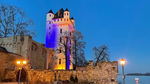 Die Kurfürstliche Burg in Eltville wird aus Solidarität mit der Ukraine in deren Nationalfarben Blau und Gelb angestrahlt.