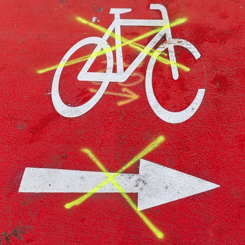 Durchgestrichene Markierungen auf einer Fahrradspur
