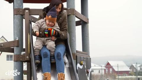 Mutter und Kind rutschen auf dem Spielplatz