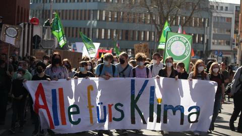 Eine Gruppe Menschen läuft durch Kassel, sie tragen ein Banner mit der Aufschrift "Alle fürs Klima"
