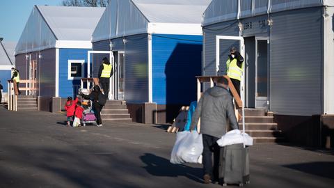 Menschen mit Türen vor Container-Häusern