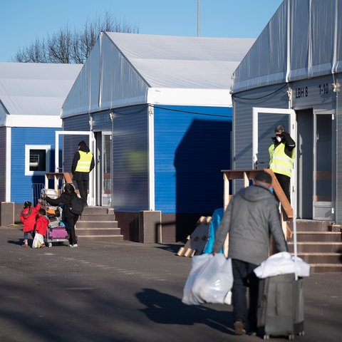 Menschen mit Türen vor Container-Häusern