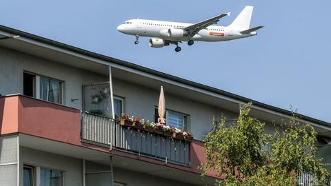 Ein Flugzeug überfliegt beim Landeanflug Wohnhäuser