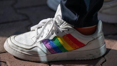 Auf einem weißtn Turnschuh wurden Regenbogenfarben aufgemalt