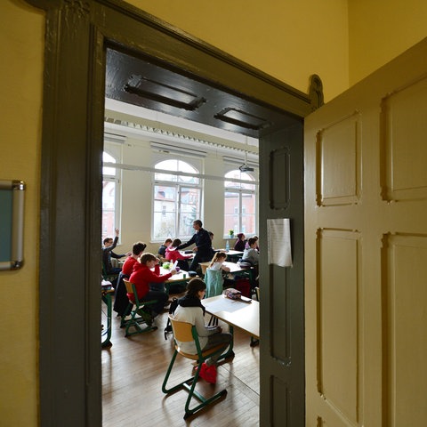 Blick in ein Klassenzimmer vom Flur durch die Tür