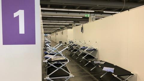 Erstversorgungszentrum in einer Frankfurter Messehalle mit aufgestellten Feldbetten.