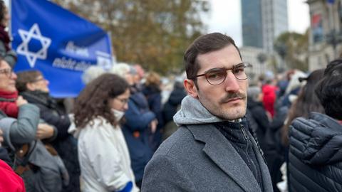Der jüdische Student Daniel Navon steht vor einem Israel-Transparent in der Frankfurter Innenstadt