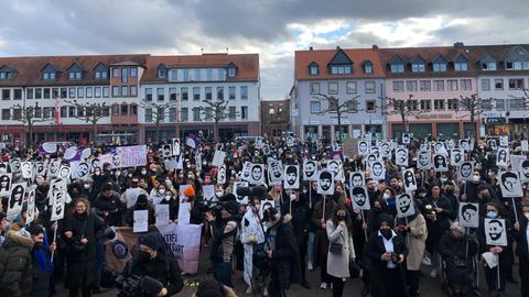 Viele Menschen stehen auf einem Platz und halten Schilder in die Höhe