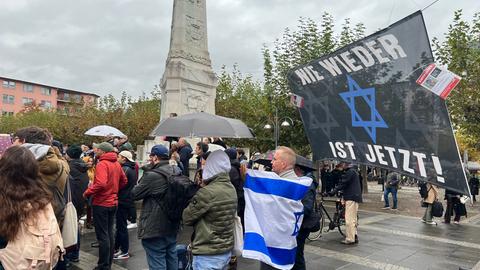 Menschen mit Regenschirmen, Bannern, Plakaten und Israelflaggen.