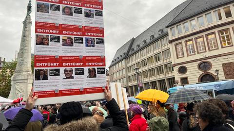 Menschen auf dem Paulsplatz vor Plakaten mit den Namen der Entführten.