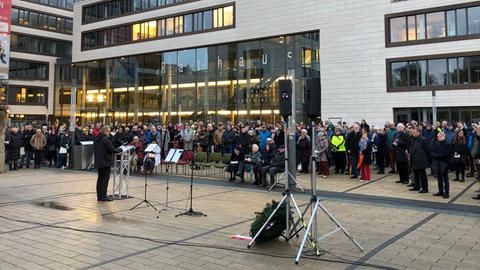 Menschenmenge vor Gießener Rathaus, in der Mitte eine Person mit Mikrofon