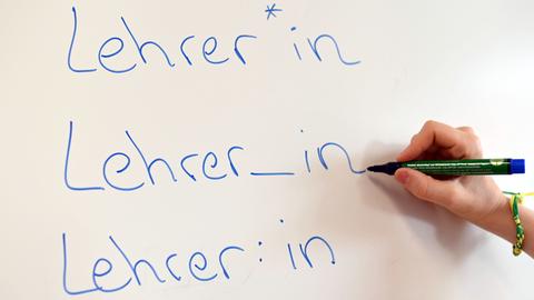 Das Wort Lehrer in drei gegenderten Versionen auf einer Tafel.