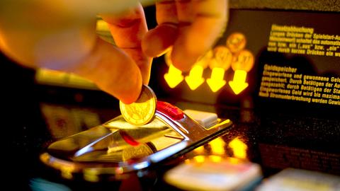 Geldspielautomat, Nahaufnahme, Mann wirft Münze in Geldschlitz