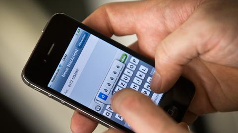 SMS wird auf Handy getippt