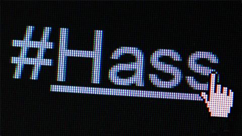 Das Wort "#HASS" auf einem LED-Bildschirm in Nahaufnahme.