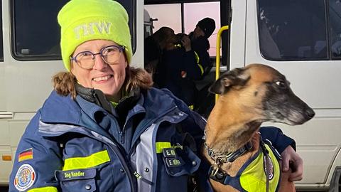 Evi Kümper mit ihrem Hund auf einer Kiste sitzend.