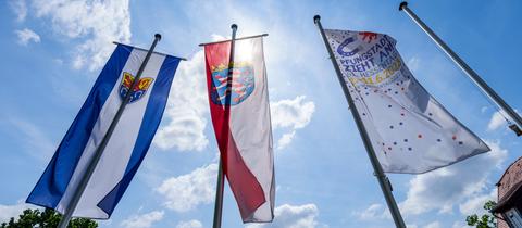 Das Wappen von Pfungstadt, der Hessen-Löwe und die "Hessentags-Flagge" wehen im Wind.