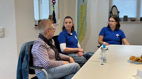 Drei Frauen sitzen im Gruppenraum der Hirntumor-Selbsthilfegruppe Mittelhessen an einem Tisch.