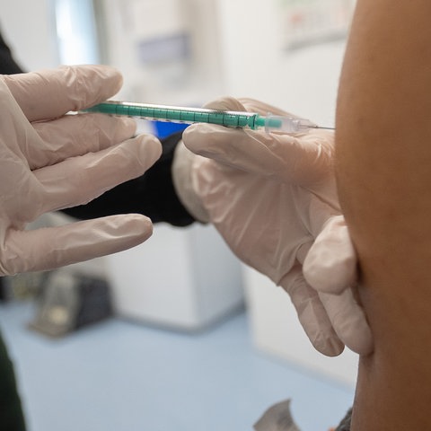 Ärztin hält Spritze gegen Coronavirus