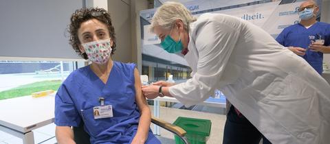 Zeynep Kallmayer (l.), Pflegerin am Frankfurter Uniklinikum, erhält am Sonntagmorgen eine der ersten Corona-Impfungen in Hessen.