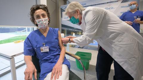 Zeynep Kallmayer (l.), Pflegerin am Frankfurter Uniklinikum, erhält am Sonntagmorgen eine der ersten Corona-Impfungen in Hessen.