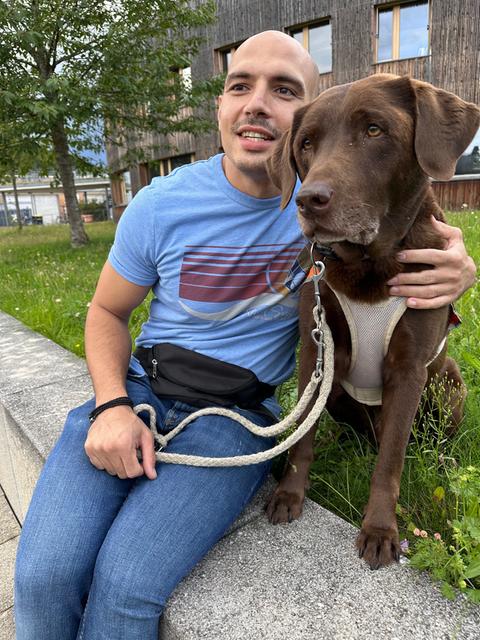 Inkluencer Niko mit seinem Blindenhund Orlando auf einer Sitzbank