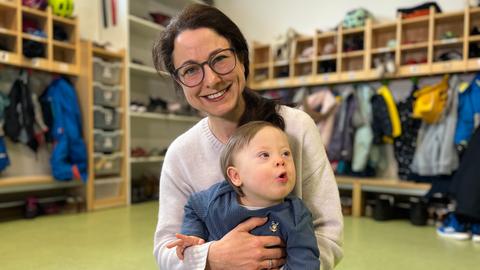 Mutter Nina Heger sitzt mit Sohn Ivo auf dem Boden in der Krabbelstube.