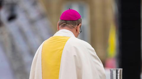 Ein Bischof im Amt während des Gottesdienstes von hinten fotografiert.