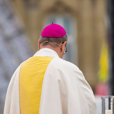 Ein Bischof im Amt während des Gottesdienstes von hinten fotografiert.