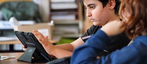 Schüler benutzt Tablet im Unterricht