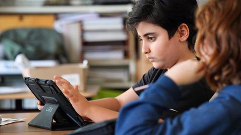Schüler benutzt Tablet im Unterricht