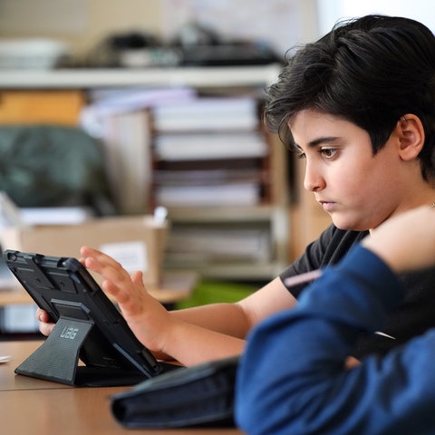 Schüler benutzt Tablet im Unterricht