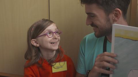 Betreuer Max Schmidt und Kind Nora lächeln sich bei einem Ohrenstark-Kurs an