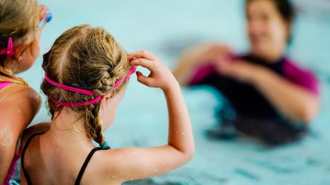 Zwei Mädchen in einem Schwimmbecken bei einem Kurs.