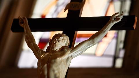 Jesus am Kreuz vor einem Kirchenfenster