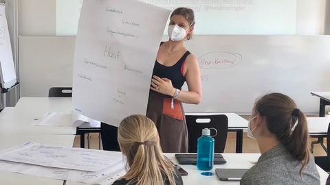 Studierende in einem Seminar, vorne eine junge Frau 