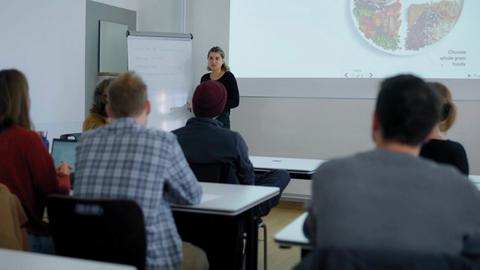 Studierende in einem Seminar, vorne eine junge Frau 