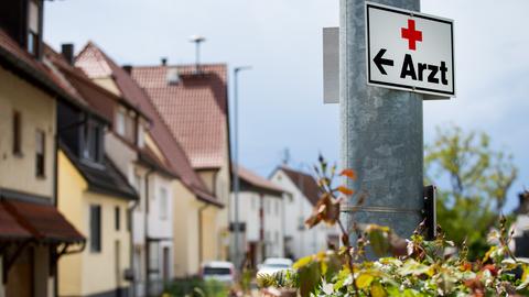 Ein Schild weist den Weg zu einer Arztpraxis.