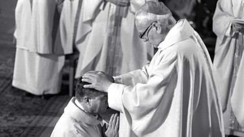 Hermann Kardinal Volk (r.) legt seinem Nachfolger als Landesbischof, Karl Lehmann, während des Pontifikalamtes im Mainzer Dom die Hände auf den Kopf. Der Freiburger Theologieprofessor Karl Lehmann wurde am 2. Oktober 1983 zum 102. Bischof von Mainz geweiht und in sein Amt eingeführt.