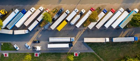 Luftaufnahme von oben: Lkw stehen auf einer Raststätte