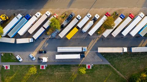 Luftaufnahme von oben: Lkw stehen auf einer Raststätte