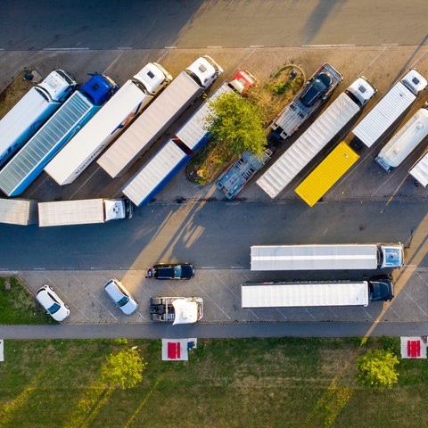 Luftaufnahme von oben: Lkw stehen auf einer Raststätte