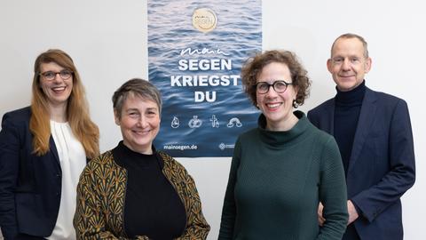 Die Pfarrerinen Charlotte Eisenberg, Katja Föhrenbach, Annegreth Schilling, Stadtdekan Holger Kamlah (v.r.n.l.) - vor dem Plakat von MainSegen - kriegst Du.