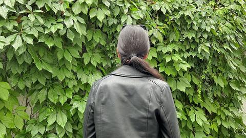 Studierende Ukraine: Dunkelhaarige Frau, von hinten fotografiert