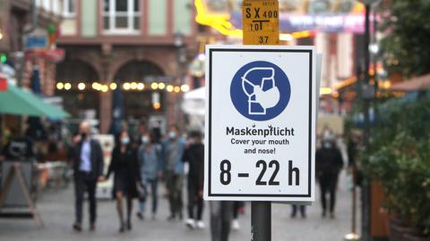 Ein Schild mit Piktogramm und Aufschrift Maskenpflicht von 8 bis 22 Uhr hängt am Römer in Frankfurt.