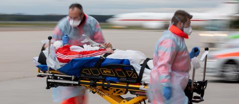 zwei Mediziner neben einem Patienten auf einer Krankentrage in Bewegung