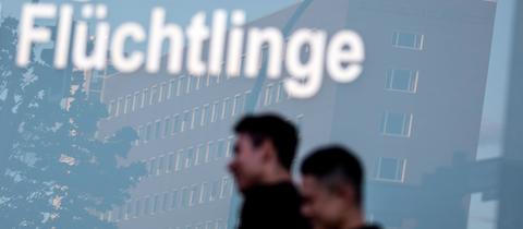 Fensterscheibe mit den Schriftzügen "Migration" und "Flüchtlinge"