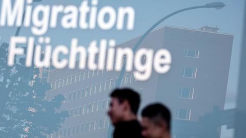 Fensterscheibe mit den Schriftzügen "Migration" und "Flüchtlinge"