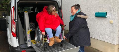 Ida Runzheimer steht mit ihrem Rollstuhl vor der Rampe des Autos.