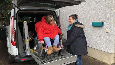 Ida Runzheimer steht mit ihrem Rollstuhl vor der Rampe des Autos.